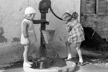 Niñas llenando un cubo de agua, 9 de mayo de 1939 (foto b/n)
