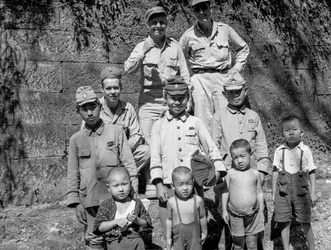 Soldados estadounidenses con familia japonesa posan juntos tras la rendición japonesa y d...