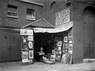 Cuadros enmarcados exhibidos fuera de una tienda de libros y cuadros de segunda mano, Londres, 1933