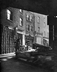 Cestas de frutas apiladas contra casas en Borough Market, Londres, 1926-1927