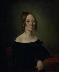 Retrato de una niña con vestido negro sentada a la mesa