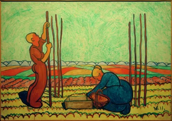 Hombre y mujer plantando postes de frijoles