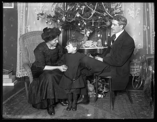 Dan Seymour y familia en pose informal, sentados bajo un árbol de Navidad, Navidad de 1912