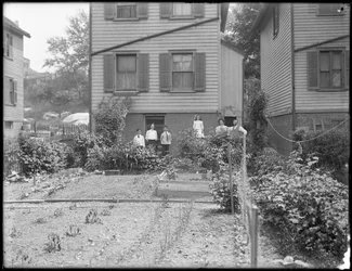 Familia posa junto a su huerto en el patio trasero, Inwood, Nueva York, hacia 1910