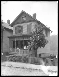 Cuatro niños posan en el porche de una casa junto a un río o lago, Inwood, Nueva York, c.1910