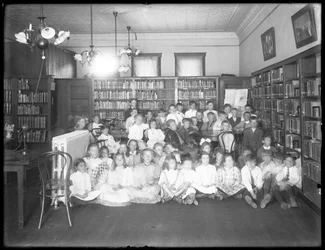 Retrato de grupo de niños en la sala de lectura de una sucursal no identificada de la Biblioteca Pública del Borough de Queens, c.1910