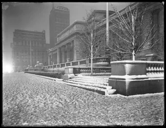 Vista nocturna de la fachada de la Quinta Avenida de la sucursal principal de la Biblioteca Pública de Nueva York en la nieve, Calle 42 y Quinta Avenida, Ciudad de Nueva York, 6 de marzo de 1915