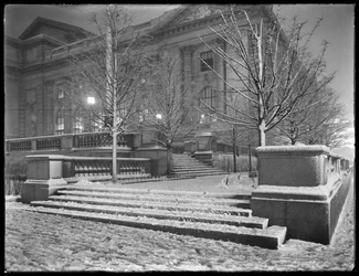 Vista nocturna de la esquina noreste de los escalones fuera de la sucursal principal de la Biblioteca Pública de Nueva York en la nieve, Calle 42 y Quinta Avenida, Ciudad de Nueva York, 6 de marzo de 1915