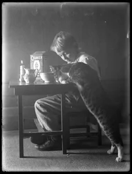 William Gray Hassler y Reddy el gato, comiendo cereal de arroz inflado Quaker, c.1912
