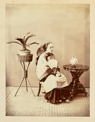 [Retrato de estudio de una joven sentada que sostiene un abanico]