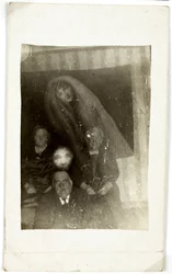 Fenómeno paranormal: retrato de tres personas mayores, el espíritu de una mujer apareciendo detrás de ellos, hacia 1920. Fotografía de William Hope (1863-1933)