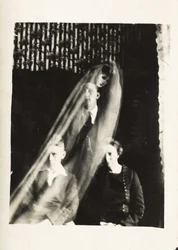 Fenómeno paranormal: retrato de una mujer y dos hombres, y el espíritu de una mujer apareciendo detrás de ellos, hacia 1920. Fotografía de William Hope (1863-1933)